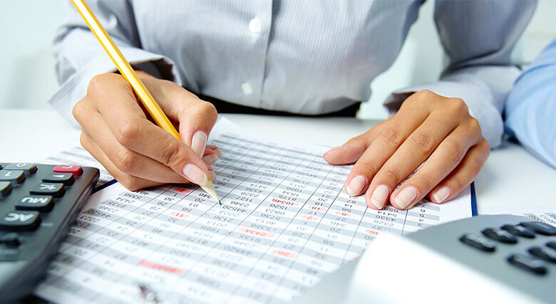 Berkeley Financial accountant reviewing financial statements with a calculator
